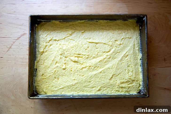 Cornbread batter spread into a 9x13-inch pan.