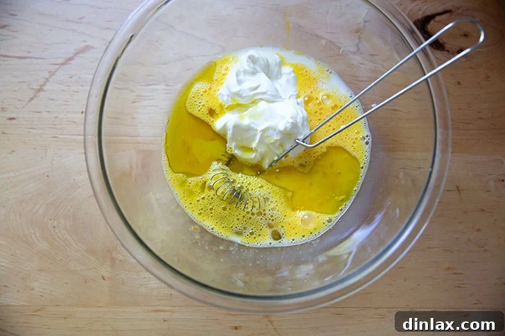 The wet ingredients to make cornbread in a large bowl.